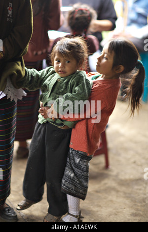 GUATEMALA CAPELLANIA jeunes indigènes Mayas Quiche girl portant sa jeune sœur Banque D'Images