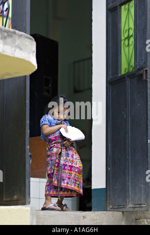 GUATEMALA SAN PEDRO LA LAGUNA indigènes Mayas Tzutujil Jeune fille en costume traditionnel s'efforce de tenir son corte tissé à la Banque D'Images