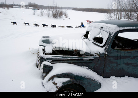 USA Alaska Anvik Musher Martin Buser et chien de traîneau de course de l'équipe passé couvert de neige abandonnés le long de la rivière Yukon camion Banque D'Images