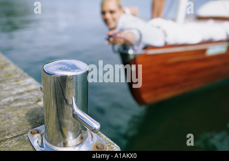 Femme sur le bateau vers atteindre bollard on jetty Banque D'Images