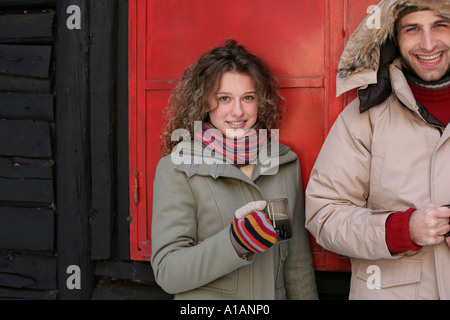 Couple dans des vêtements d'hiver avec les boissons chaudes Banque D'Images