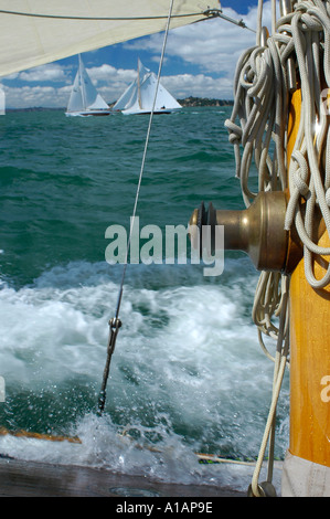 Un treuil laiton et conduites d'crampons sur le mât d'un voilier classique d'une course contre deux autres bateaux disponibles Banque D'Images