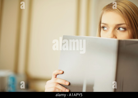 Woman peering sur le dessus du dossier Banque D'Images