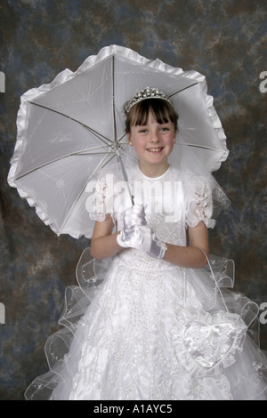 La première communion catholique tourné d'une jeune fille irlandaise en robe blanche avec parasol blanc Banque D'Images