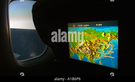 Moniteur de carte de l'Eurasie et de vol en route du Japon s'assombrit cabine avec fenêtre et vue sur l'aile d'un Boeing 747 Banque D'Images