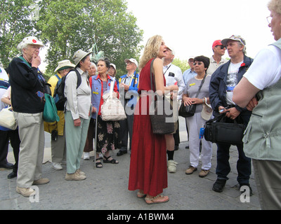 Guide en robe rouge montrant les touristes autour de Paris Banque D'Images