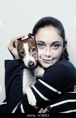 Jeune fille tenant un chien chiot Jack Russell Banque D'Images