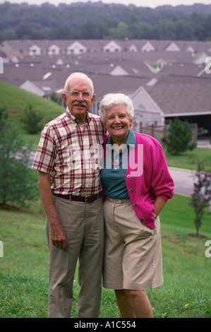 Un couple actif pose sur une colline avec vue sur leur collectivité de retraités dans le Maryland model publié Banque D'Images