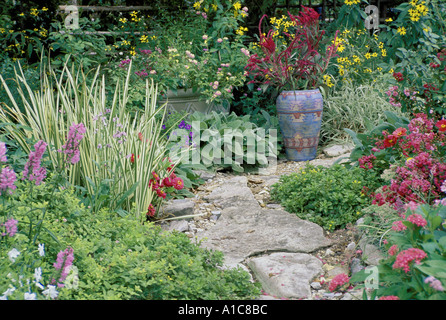 Chemin de dalles colorées en arrière-cour en fleurs jardin fleuri avec un pot en céramique mexicaine fait main MO, USA Banque D'Images