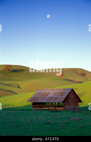 Grange rouge au lever du soleil dans les collines vertes de Californie East bay area American farmland Banque D'Images