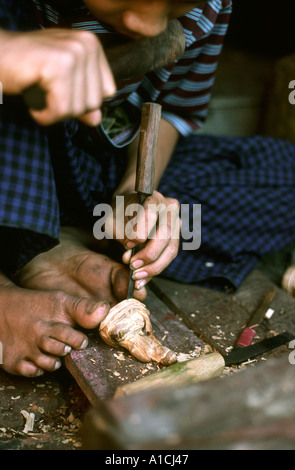 Mandalay Birmanie Myanmar sculpteur sur bois artisanat holding Bouddha à pieds tout en carving Banque D'Images