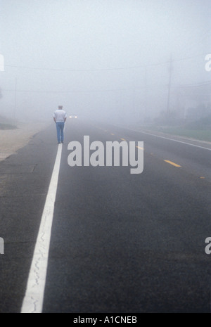 Homme qui marche dans le brouillard Banque D'Images