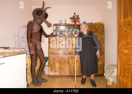 Vieille Femme et un homme de grande taille en costume de moustiques dans une vieille cuisine Banque D'Images