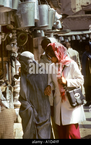 Deux femmes dans une burqa les vêtements occidentaux et sac à main shopper shopping boutique foulard acheter acheter à pied la rue fenêtre contraste de style Banque D'Images