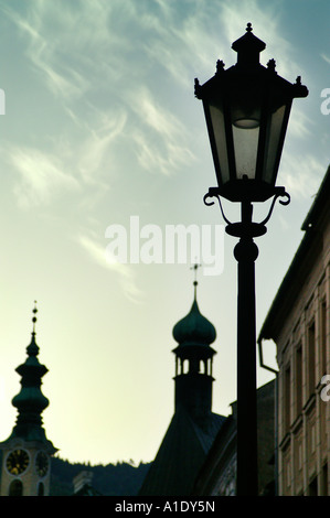 Lampadaire et maisons historiques church tower spire et ciel bleu dans la ville de Banska Stiavnica, Slovaquie Banque D'Images