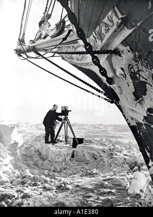 Frank Hurley avec caméra vidéo sur la glace sous la proue de l'expédition Antarctique Trans impériale d'Endurance Banque D'Images