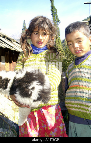 Deux jeunes indiens autochtones enfant Fille Garçon jouant avec des serviettes blanches chien chiot mignon Kalga, village, Inde Banque D'Images