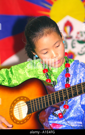 Jeune fille tibétaine chanteuse interprète de musique arts en face du drapeau national du Tibet Banque D'Images