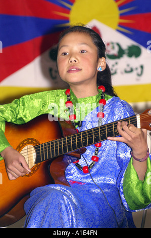 Jeune fille tibétaine chanteuse interprète de musique arts en face du drapeau national du Tibet Banque D'Images