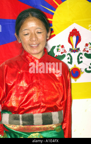 Ancienne danseuse interprète de danse arts tibétains en face de drapeau national du Tibet Banque D'Images