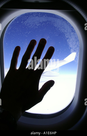 Fenêtre ronde d'airbus avion aile d'avion au-dessus des nuages lumineux blanc épais et ciel bleu azur haute altitude Banque D'Images