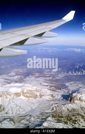 Aile d'avion Airbus plane au-dessus de montagnes du Caucase et ciel bleu azur haute altitude Banque D'Images