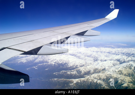 Aile d'avion Airbus plane au-dessus de montagnes du Caucase et ciel bleu azur haute altitude Banque D'Images