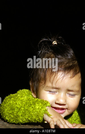 Portrait de très jeunes filles indan visage souriant avec pull vert, fond noir Banque D'Images