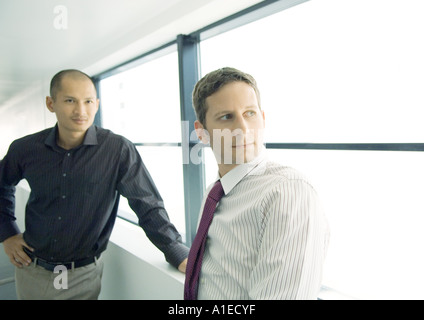 Deux hommes debout près de window Banque D'Images