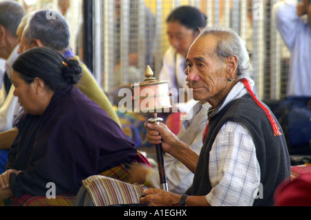 Visiteurs en monastère de Namgyal spinning à prière personnelle des mains pendant la prière Banque D'Images