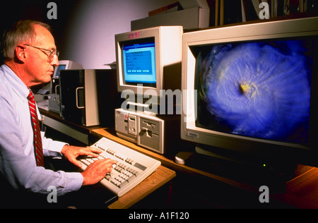 Spécialiste de l'informatique à la National Oceanic Atmospheric Administration NOAA avec une image de l'ouragan Emily à l'écran Banque D'Images