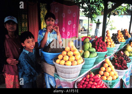 Les enfants vente de fruits sur la route de l'Indonésie Bali Banque D'Images