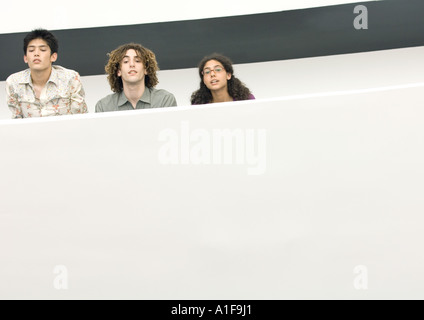 Trois jeunes gens à la recherche sur le bord de balcon Banque D'Images