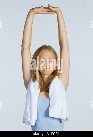 Woman stretching arms over head Banque D'Images