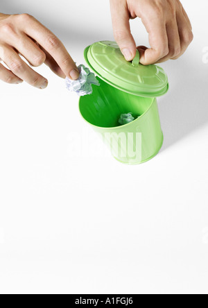 Mettre les mains dans la petite corbeille poubelle Banque D'Images