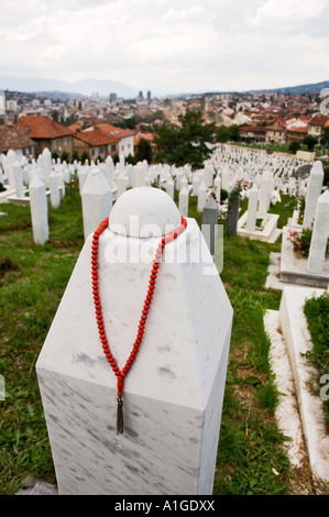 La prière musulmane beads pendre un mémorial pierre tombale dans un cimetière de guerre Sarajevo Bosnie-Herzégovine Banque D'Images