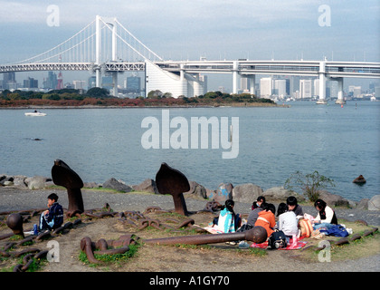 Un groupe d'écoliers prennent leur déjeuner sur le front de l'eau au cours d'un voyage scolaire à Odaiba à Tokyo Banque D'Images