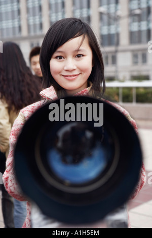 Close-up d'un télescope en face d'une jeune femme Banque D'Images