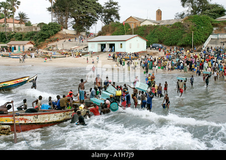 Les jeunes hommes wade en surf bateau de pêche de la Gambie Bakau Banque D'Images