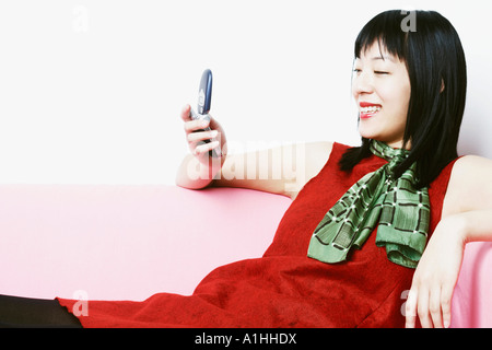 Close-up of a young woman holding a mobile phone Banque D'Images