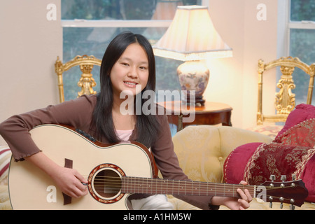 Portrait d'une jeune fille jouant de la guitare Banque D'Images