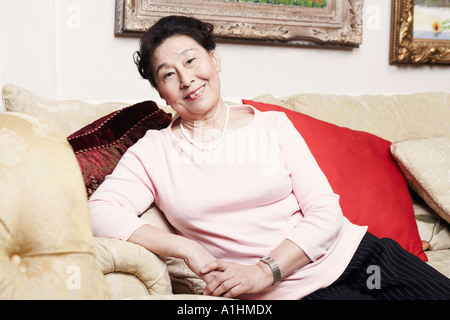 Portrait of a senior woman sitting on a couch Banque D'Images