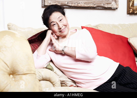 Portrait of a senior woman sitting on a couch Banque D'Images