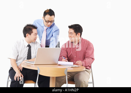 Close-up de trois hommes d'affaires de discuter en face d'un ordinateur portable Banque D'Images