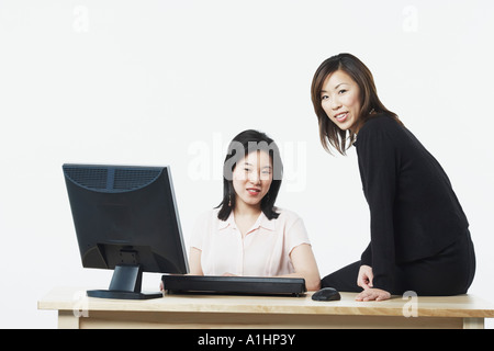 Portrait of two businesswomen smiling in front of a computer Banque D'Images