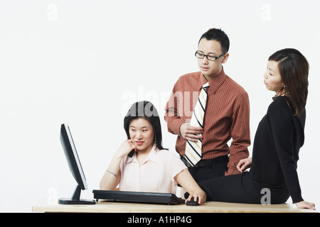 Deux femmes d'affaires et d'un businessman looking at a computer monitor Banque D'Images