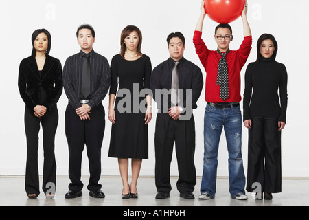 Portrait d'un jeune homme debout tenant une balle avec un groupe de cadres d'entreprise Banque D'Images