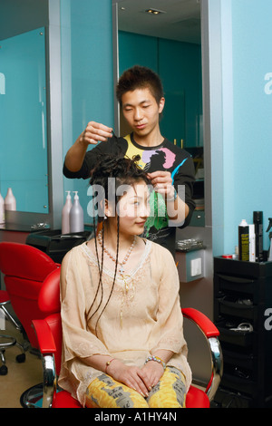 Coiffure masculine avec l'adolescente dans un salon Banque D'Images