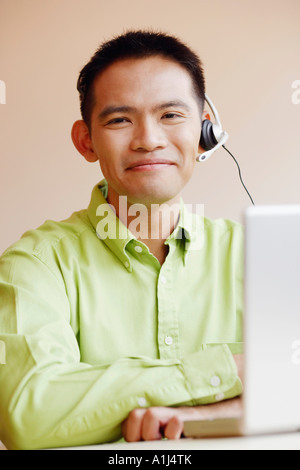 Portrait d'un homme Représentant du service à la clientèle à l'aide d'un laptop and smiling Banque D'Images
