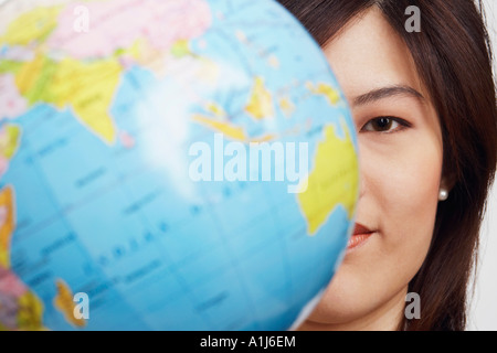 Portrait d'une femme avec un globe en face d'elle Banque D'Images